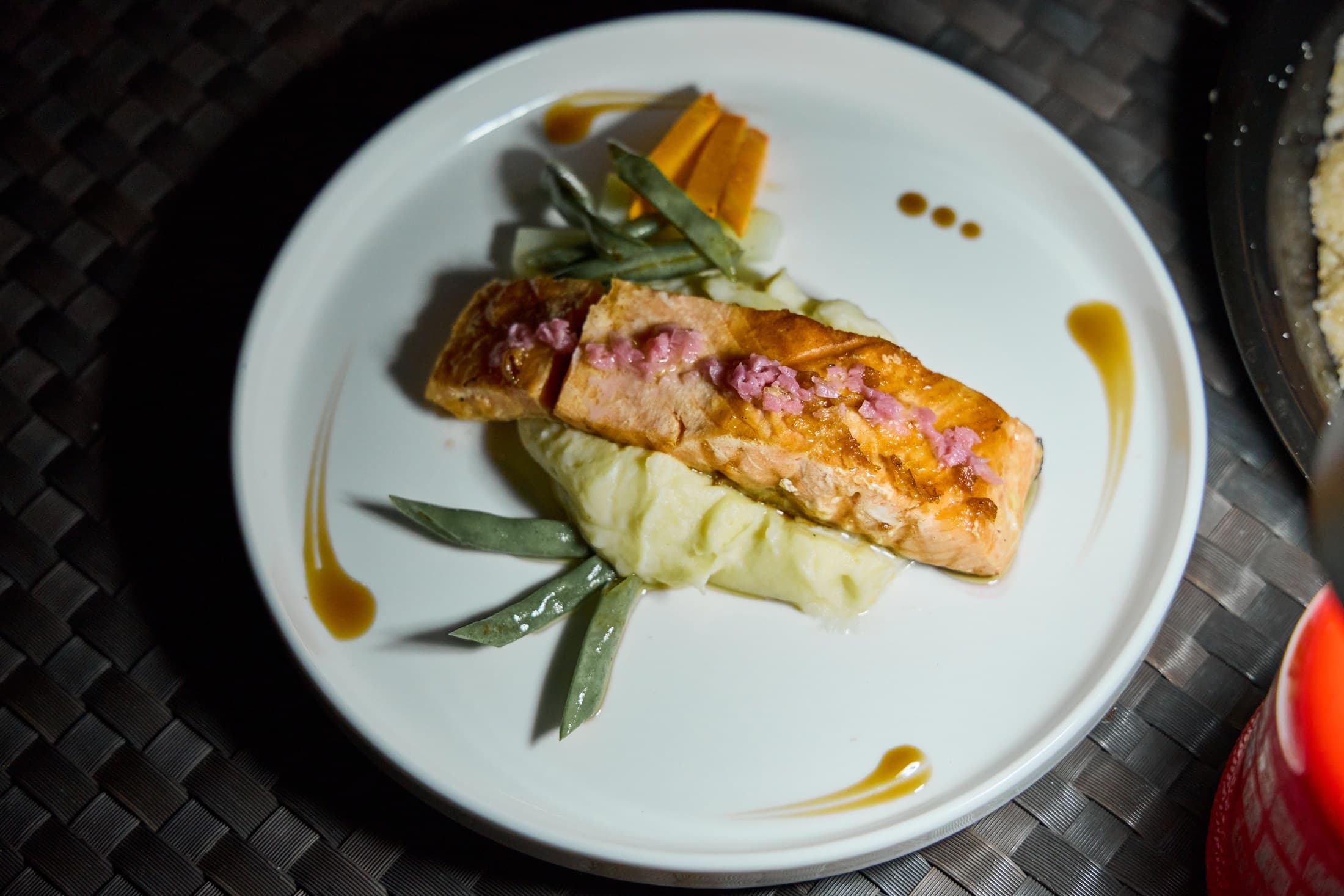 A plated salmon dish with vegetables and sauce at G Bistro