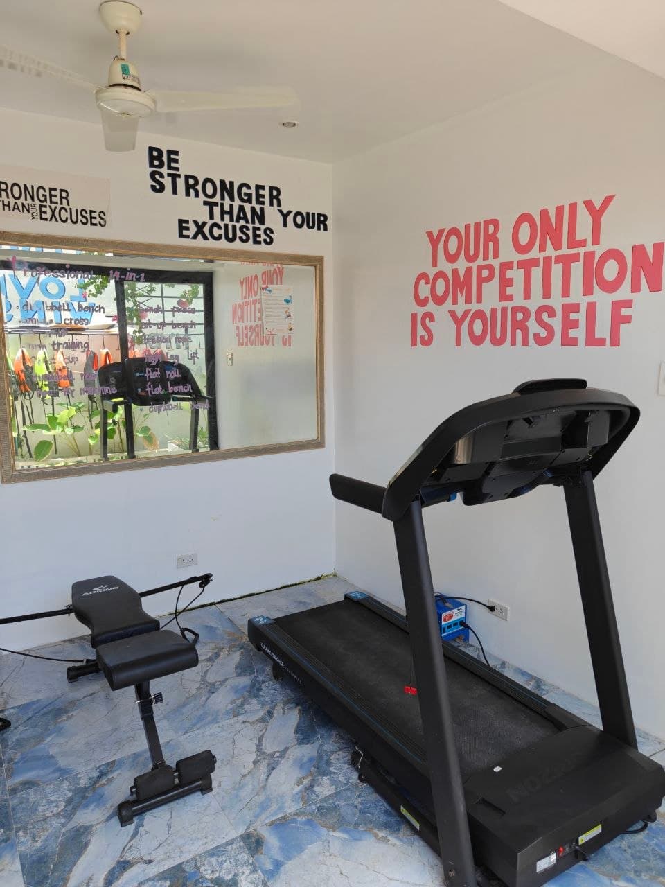 The G Boutique gym room with treadmill and exercise bench