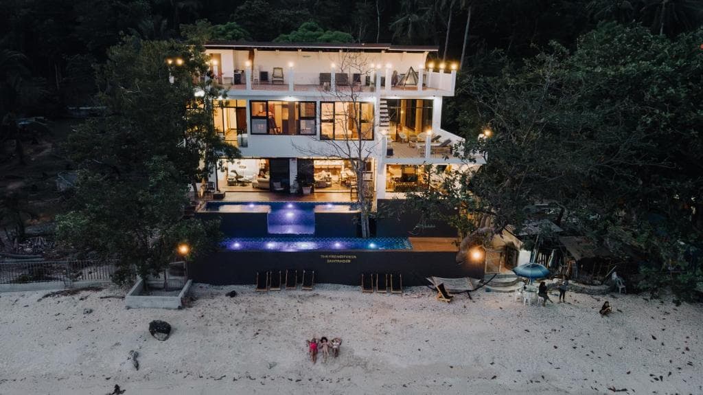The villa, lit from the beach